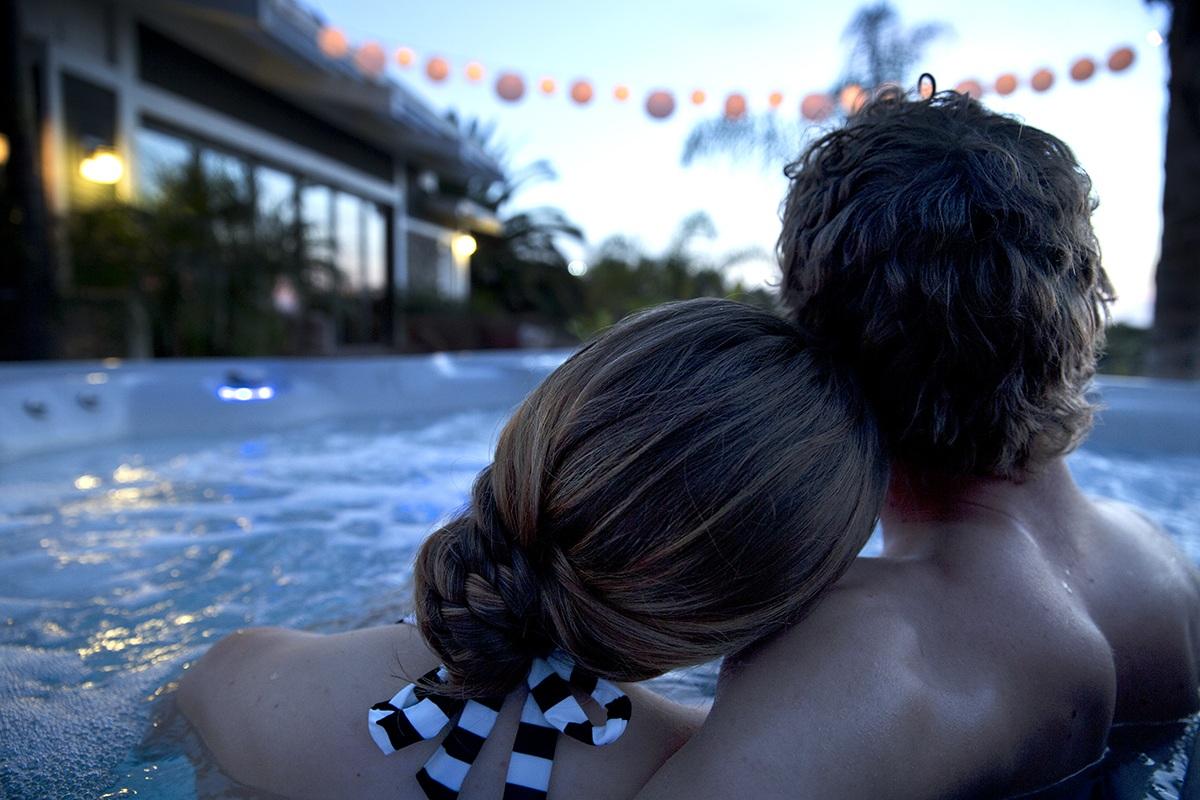 a romantic couple enjoys a soak in a highlife vanguard hot tub at night