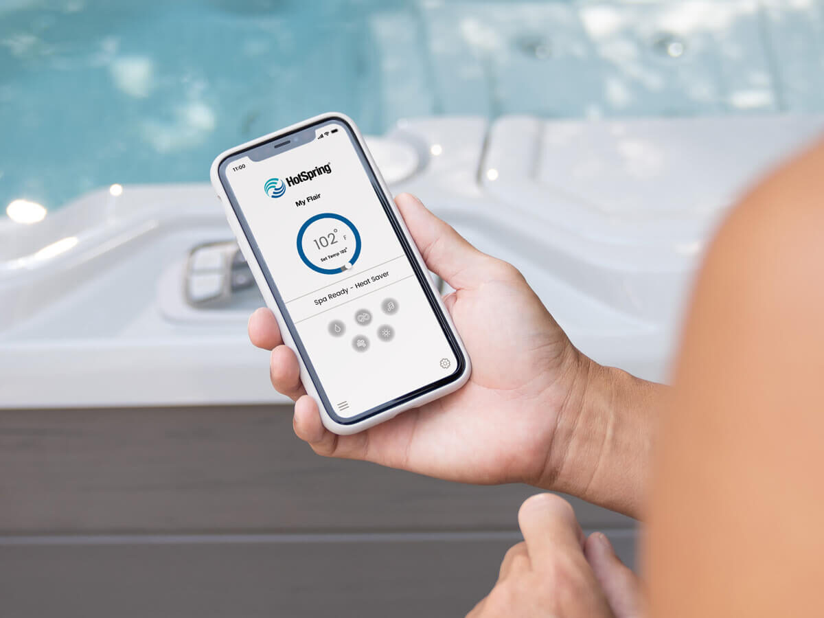 A mobile phone displaying the Hot Spring Spas App, showcasing the seamless control and management of the connected spa experience.
