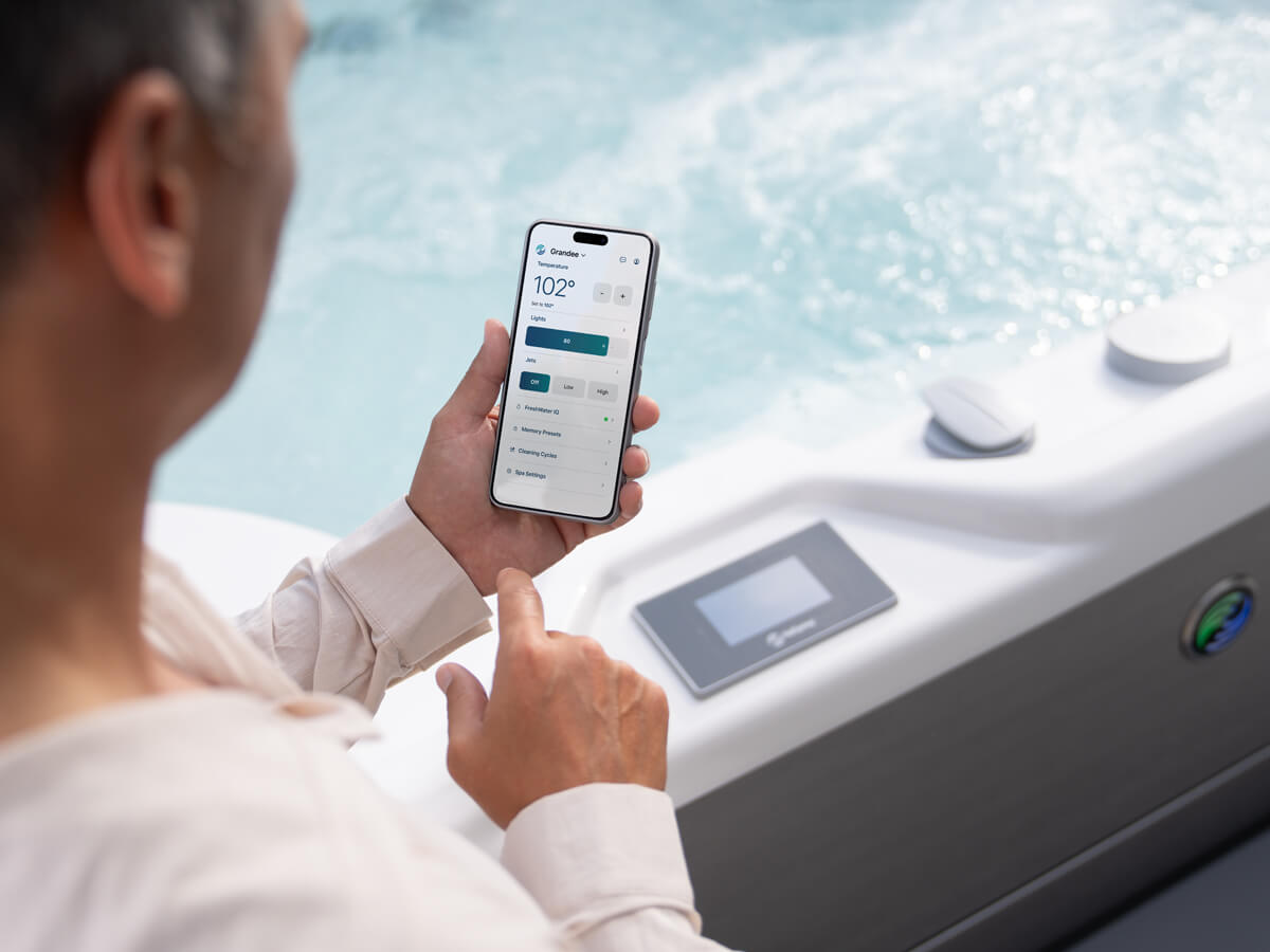 Hot Spring spa owner checking water-care status with the FreshWater IQ® Smart Monitoring System on her smartphone.